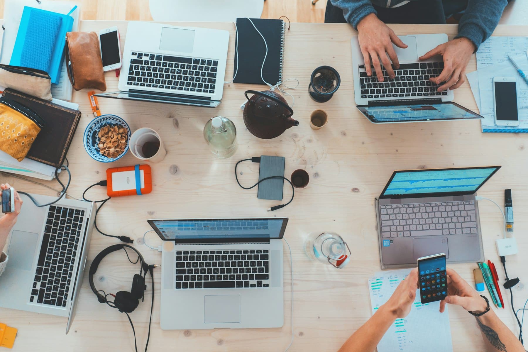A team working together around a table of laptops